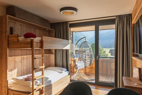 a bedroom with a bunk bed and a large window at Boutiquehotel Acherl in Achenkirch
