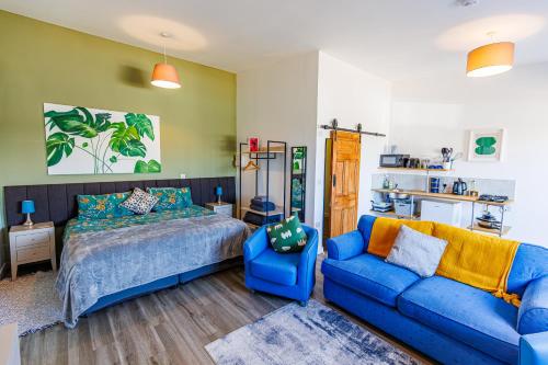 a bedroom with a bed and a blue couch at Modern Barn Conversion in Brackley