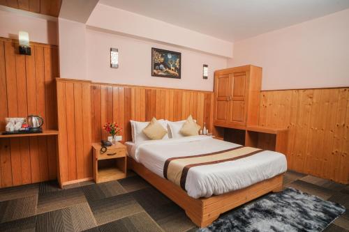 a bedroom with a large bed with wooden paneling at Verdant The Vintage in Lachung