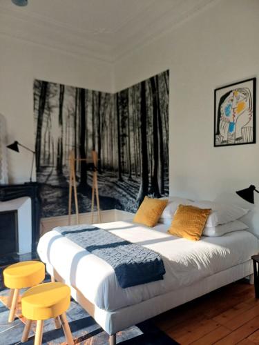 a bedroom with a large bed with two yellow chairs at La Petite Porte Verte in Bouilland