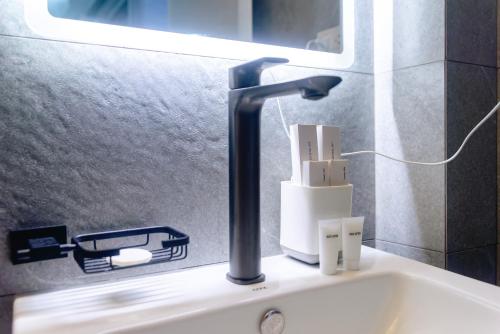 a bathroom sink with a black faucet on it at Philla D Afrique Resort in Inopacan
