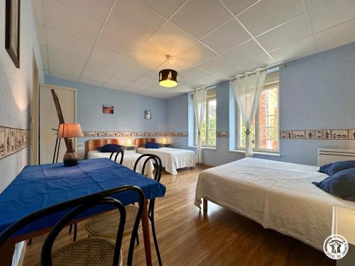 a bedroom with two beds and a table in it at La Maison du Parc in Les Maillys