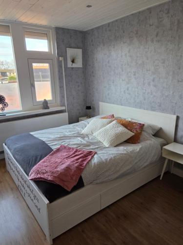 a white bed in a bedroom with a window at Heerlijk dromen in 't Maantje in Waalwijk