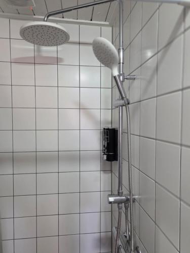 a shower with two lights on a white tiled wall at Heerlijk dromen in 't Maantje in Waalwijk