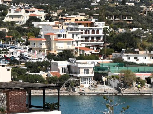 a group of white buildings next to a body of water at SUMMER Home in Agios Nikolaos