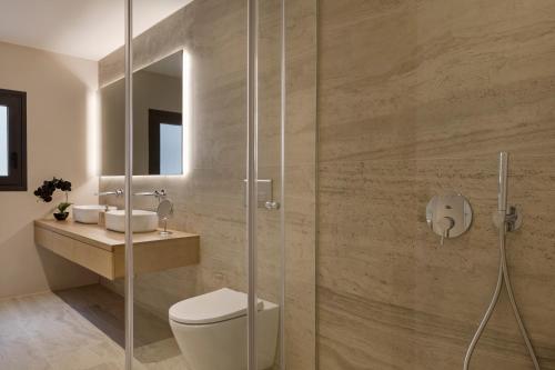 a bathroom with a toilet and a glass shower at September Athens Residences in Athens