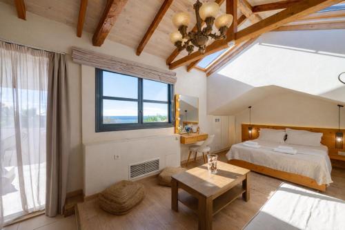 a bedroom with a bed and a large window at Panellinion Luxury Rooms in Kalamata