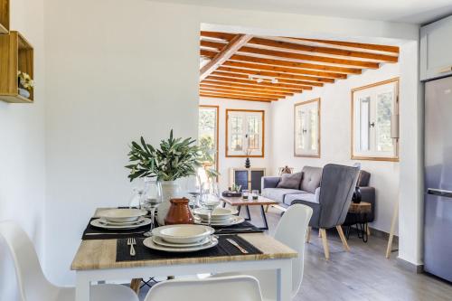 a dining room and living room with a table and chairs at Solea Cottage - Bright Escape in Skopelos in Skopelos Town