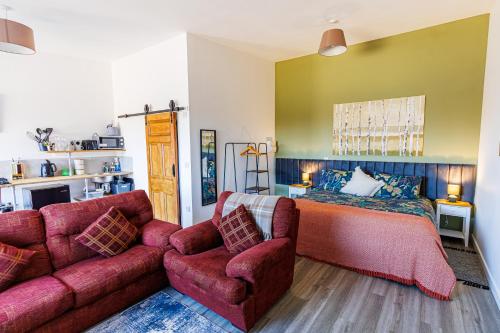 a living room with a couch and a bed at Modern Barn Conversion in Brackley