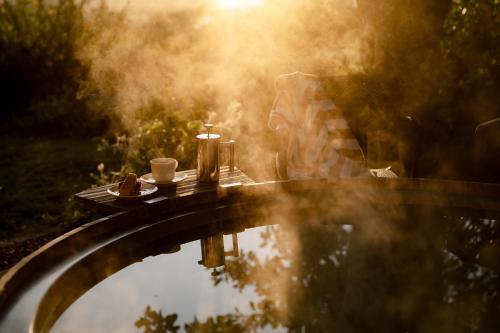 a picnic table with a cup of coffee and a candle at Pezula Nature Retreat in Knysna