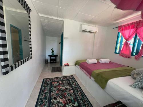 a small bedroom with a bed and a rug at Benny beach house in Ko Samed