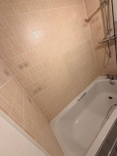a bath tub in a bathroom with tiled walls at Springfield garden-Celtic park in Glasgow