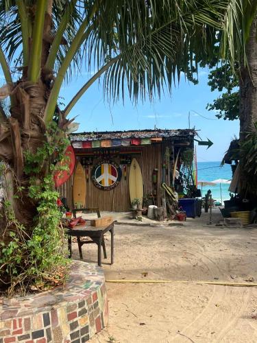 a building on the beach with a table and a tree at Benny beach house in Ko Samed