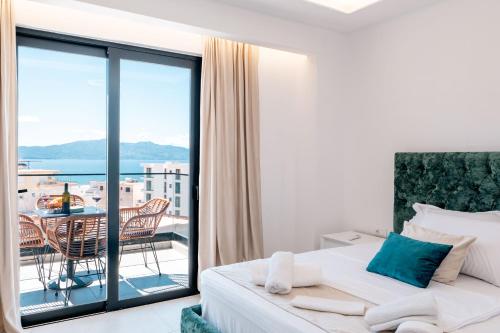 a bedroom with a bed and a balcony with a table at Seaview Deda 02 in Sarandë