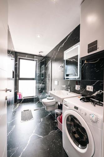 a bathroom with a washing machine and a sink at Seaview Deda 02 in Sarandë