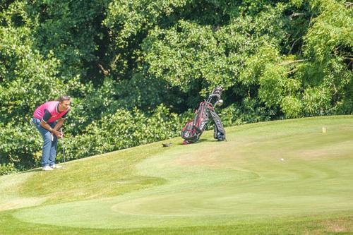 a man playing golf on a golf course at Woodbury Park Hotel & Spa in Exeter
