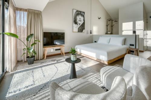 a bedroom with a bed and a living room at Van Heeckeren City Centre Jacuzzi Lofts in Nes