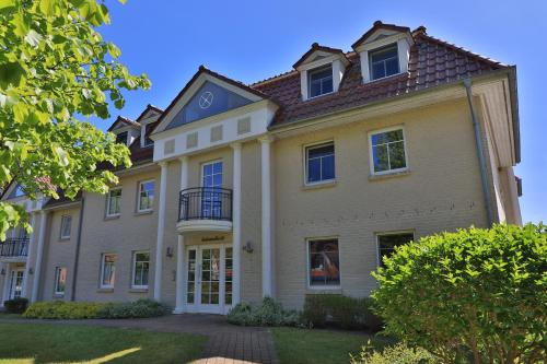 a large yellow house with a brown roof at 2 Zimmer Appartement Poseidon in Boltenhagen
