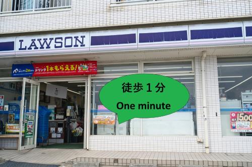 a one minute sign in front of a store at IZA Kamakura Guest House and Bar in Kamakura