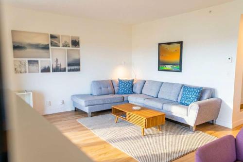 a living room with a couch and a coffee table at Luxury Condo with Stunning View and Pool in Baie-Saint-Paul