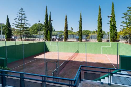 a tennis court with a net at LuxSevilla Apartment Piscina in Bormujos