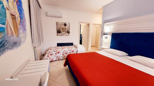 a bedroom with two beds and a red blanket at Olimpo degli Dei in Agerola