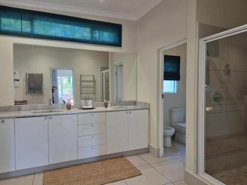 a bathroom with two sinks and a shower at Milner Manor in Grahamstown
