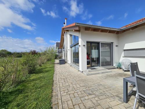 a white house with a patio and grass at Holidayhouse4You in Schwanau
