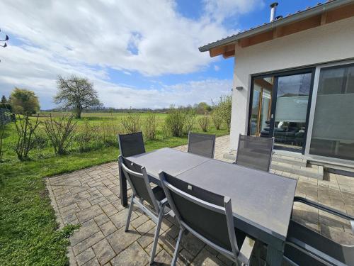 a table and chairs on a patio with a view of a field at Holidayhouse4You in Schwanau
