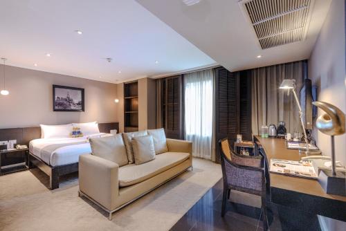 a hotel room with a bed and a chair and a desk at S15 Sukhumvit Hotel in Bangkok