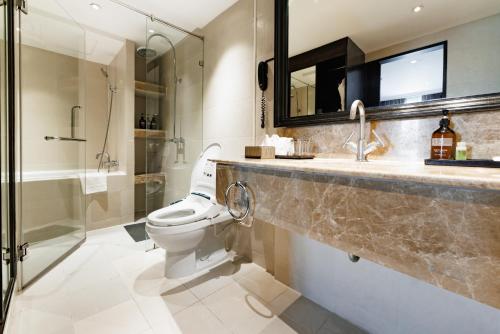 a bathroom with a toilet and a sink and a shower at S15 Sukhumvit Hotel in Bangkok