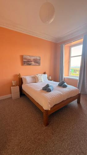 a bedroom with a large bed with a window at Vistamar Dunoon in Dunoon