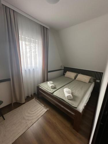 a bedroom with a bed with two towels on it at KörösPartOn in Békésszentandrás