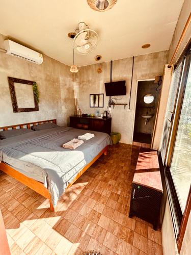 a bedroom with a bed and a flat screen tv at Tchin tchin Guesthouse in Ko Chang