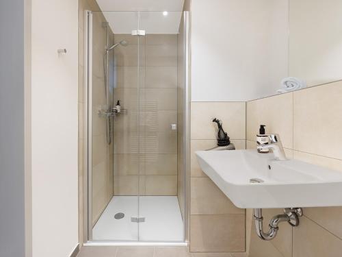 a bathroom with a sink and a shower at smartments Frankfurt Airport in Frankfurt
