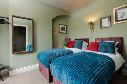 a bedroom with two beds with blue and red pillows at Spacious 2 Bed House Lancaster in Lancaster