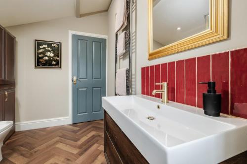 a bathroom with a white sink and a blue door at Spacious 2 Bed House Lancaster in Lancaster