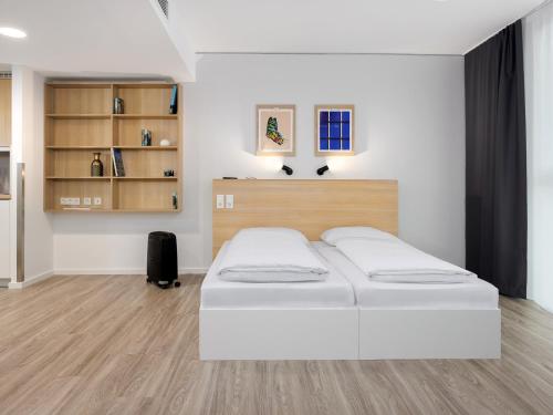 a bedroom with a white bed in a room at smartments Frankfurt Airport in Frankfurt