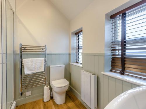 a bathroom with a toilet and a window and a radiator at The Gables Studio in Keswick
