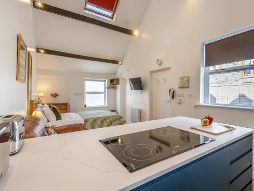 a kitchen with a sink and a living room at The Gables Studio in Keswick