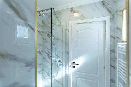 a shower with a glass door in a bathroom at Jolie Boutique Hotel Corp B in Craiova
