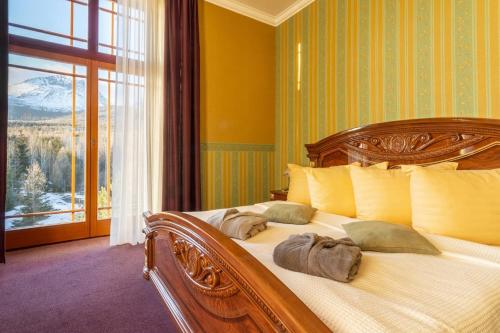 a bedroom with a large bed with pillows and a window at Kúpeľný dom GERLACH in Vysoké Tatry