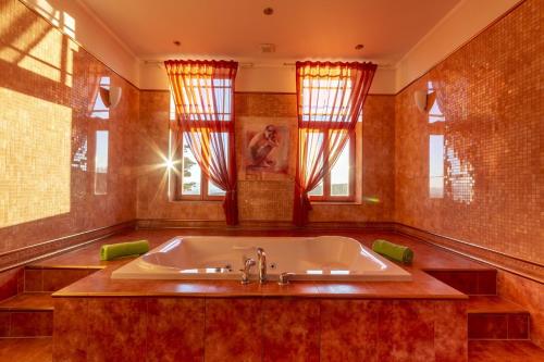 a large bathroom with a tub and windows at Kúpeľný dom GERLACH in Vysoké Tatry