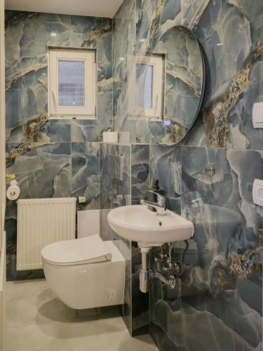 a bathroom with a sink and a toilet and a mirror at Garden Apartments in Prague