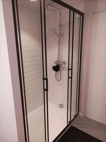 a shower with glass doors in a bathroom at Les 3 Platanes in Conilhac-Corbières