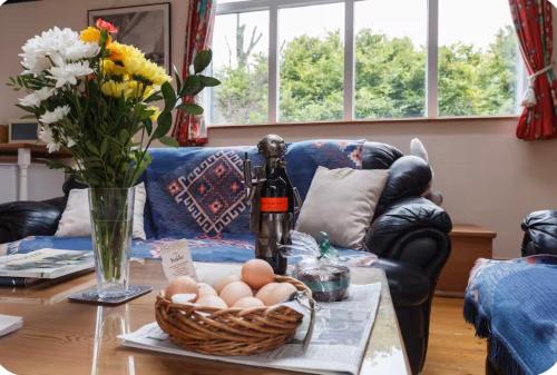 a living room with a table with eggs and a bottle of wine at Spout House Studio in Boldre