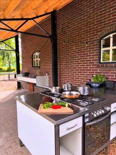 an outdoor kitchen with a counter with pots and pans at Bell Tent in een Voedselbos in Nederweert-Eind
