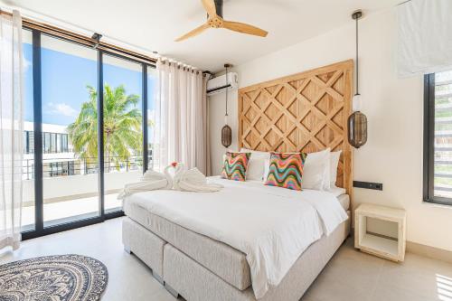 a bedroom with a large bed and a large window at Van der Valk Plaza Resort Bonaire - All Inclusive in Kralendijk