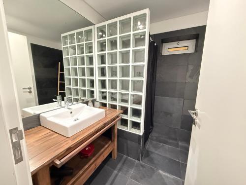 a bathroom with a sink and a glass wall at Sea Sound Apartment by Trip2Portugal in Sesimbra