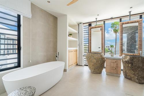 a bathroom with a white tub and a large window at Van der Valk Plaza Resort Bonaire - All Inclusive in Kralendijk